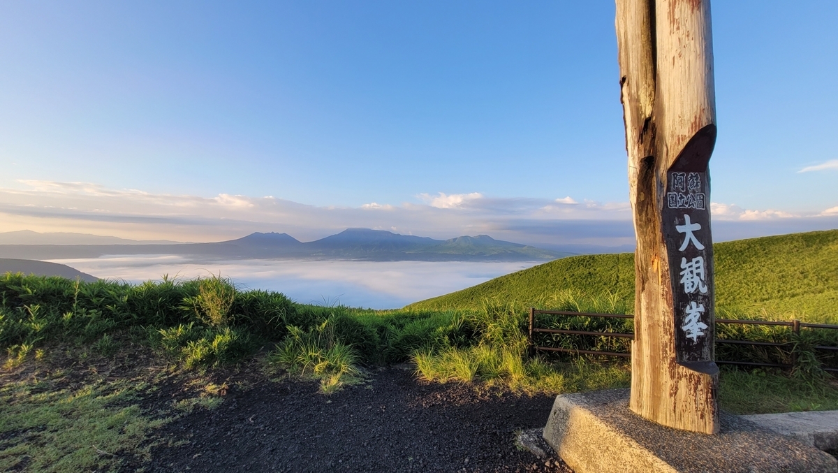 大观峰的木制标柱与清晨云海覆盖的阿苏火山口景色