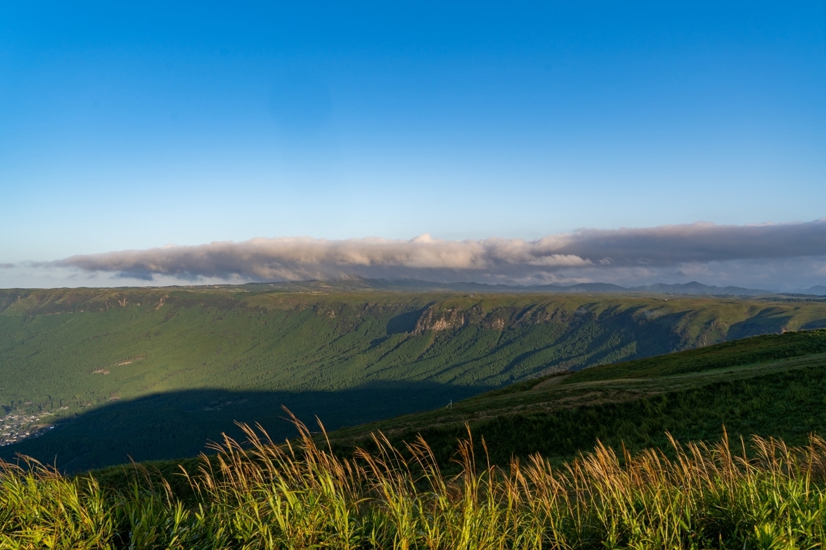 大观峰草原远处连绵的外轮山山脊与横卧的云带