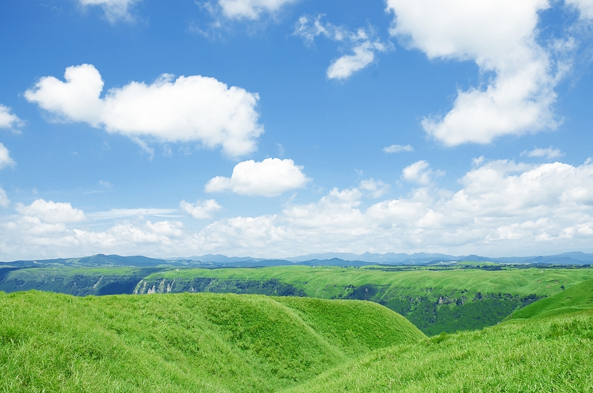 草原绿色山丘连绵的外轮山与夏日天空中漂浮的积云