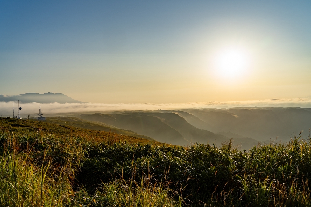 夕阳下的大观峰草原与漂浮在云海上的外轮山山脊