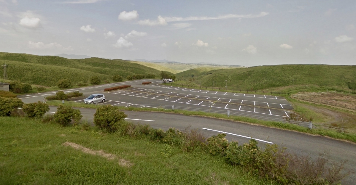 被绿色山丘环绕的宽敞第2停车场的停车位