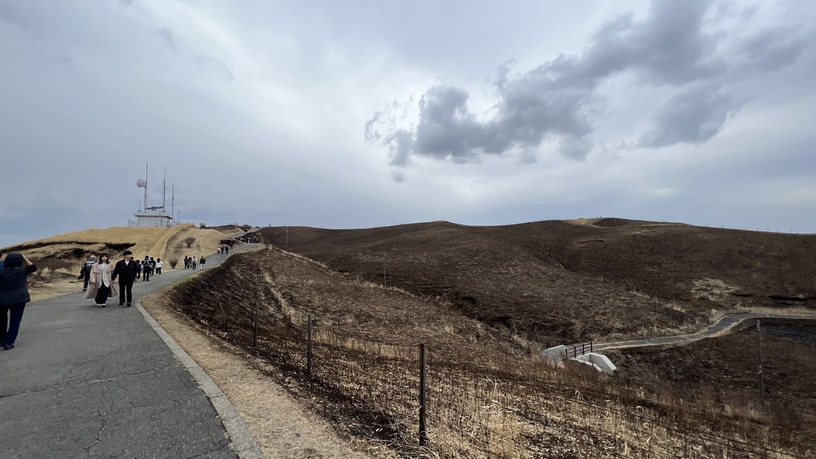 沿着烧焦的山坡前行的观景台铺装道路与步行的游客