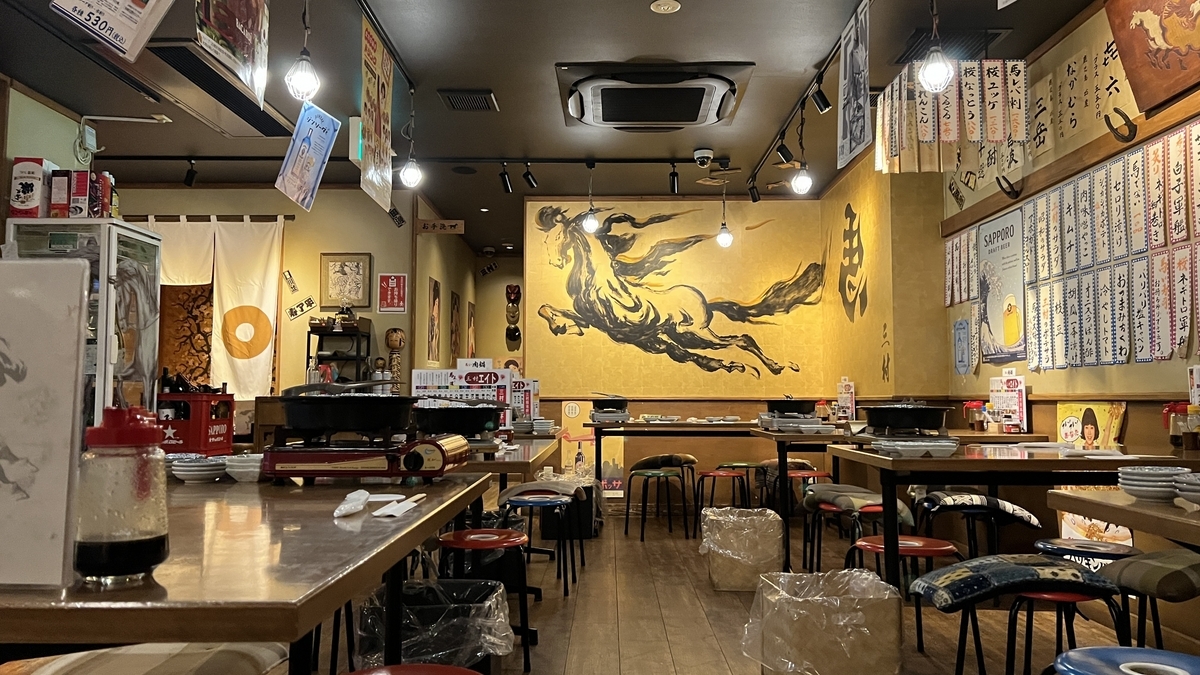 三村店内的餐桌席、满墙菜单和马匹壁画