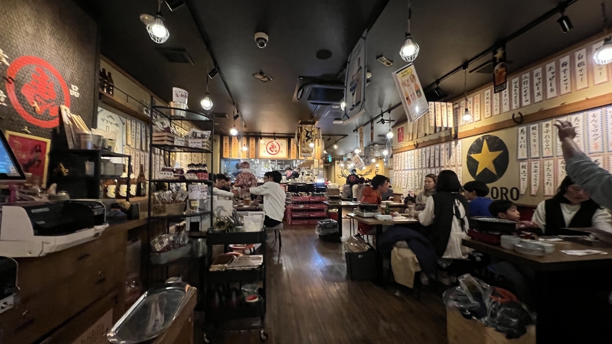 几乎满座的三村店内用餐的客人和墙上的菜单