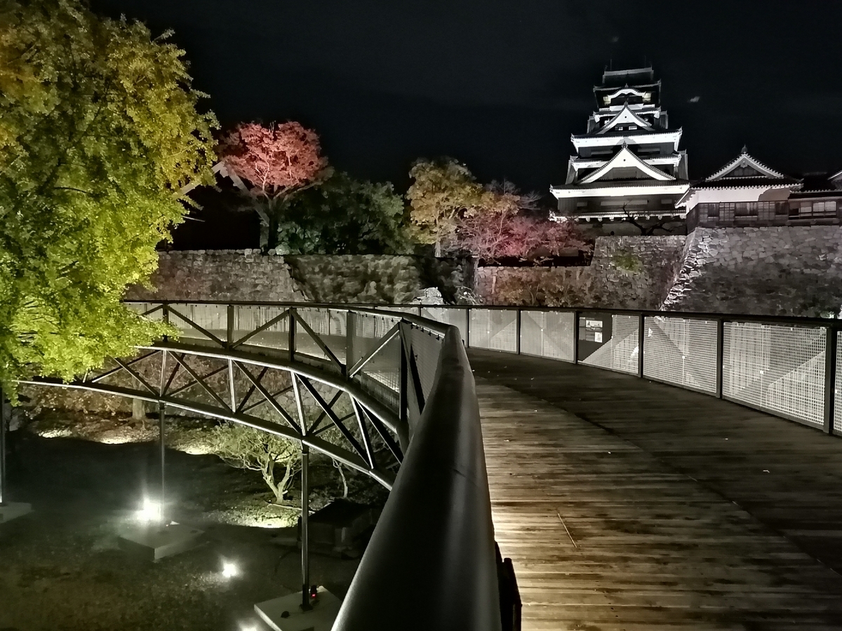 木制步道和透过石垣看到的灯光秀下熊本城天守阁