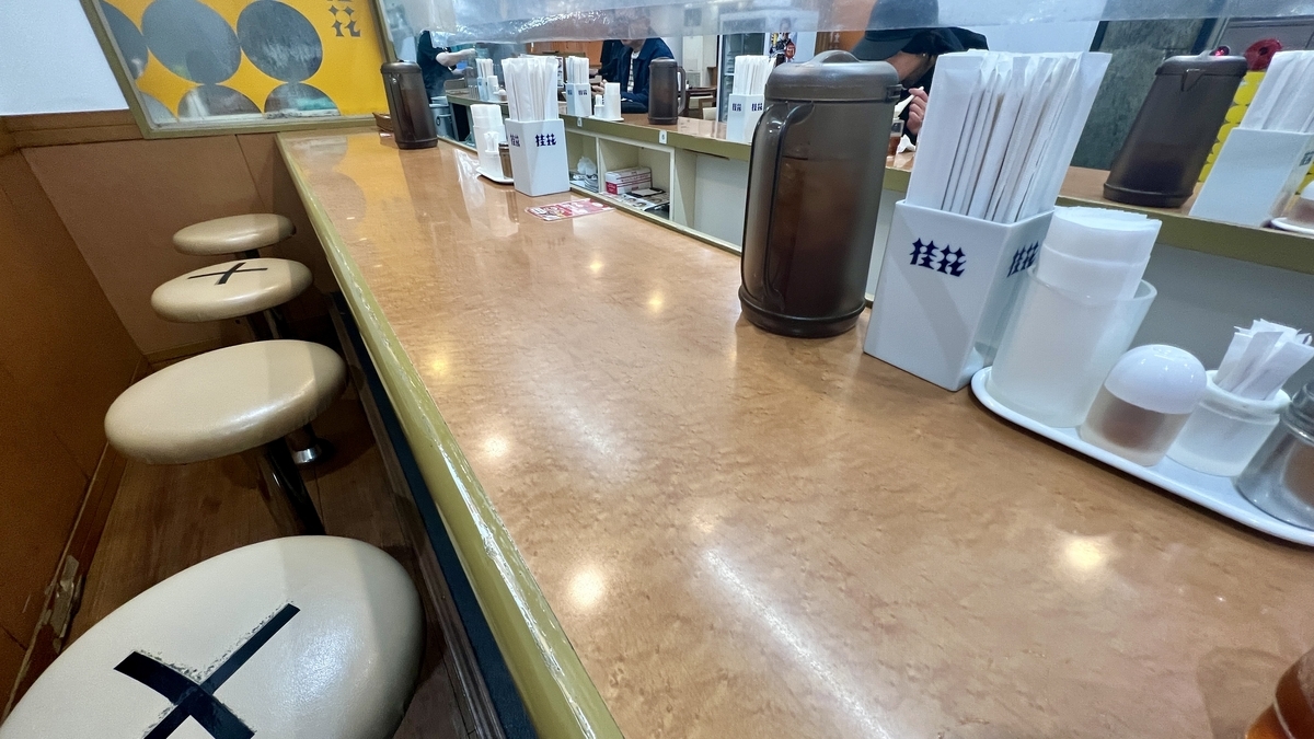 木质吧台与圆凳整齐排列的桂花本店内部