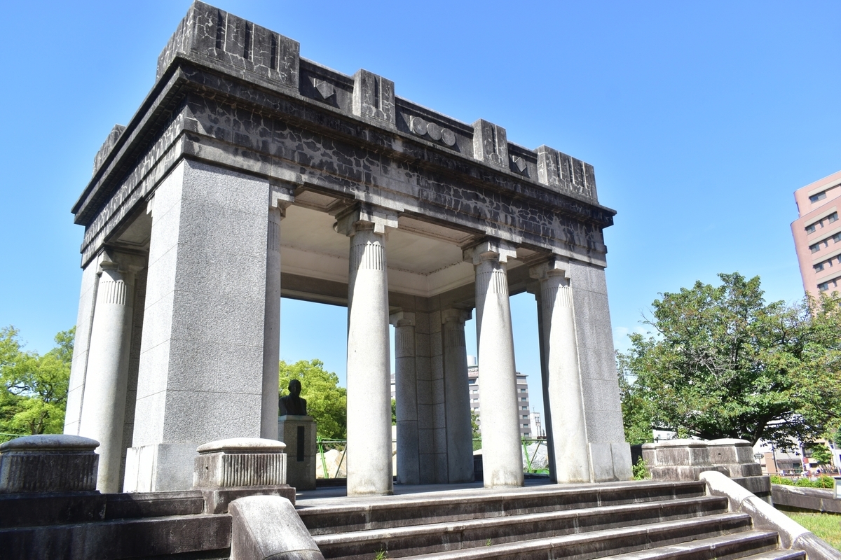 仰望旧熊本市政厅门廊爱奥尼亚式石柱和湿润石阶的构图