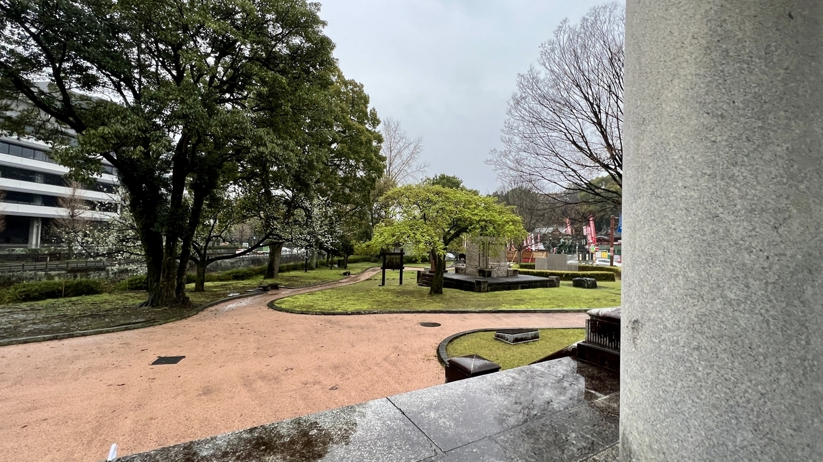 透过旧熊本市政厅门廊遗构柱子看到的高桥公园曲线园路