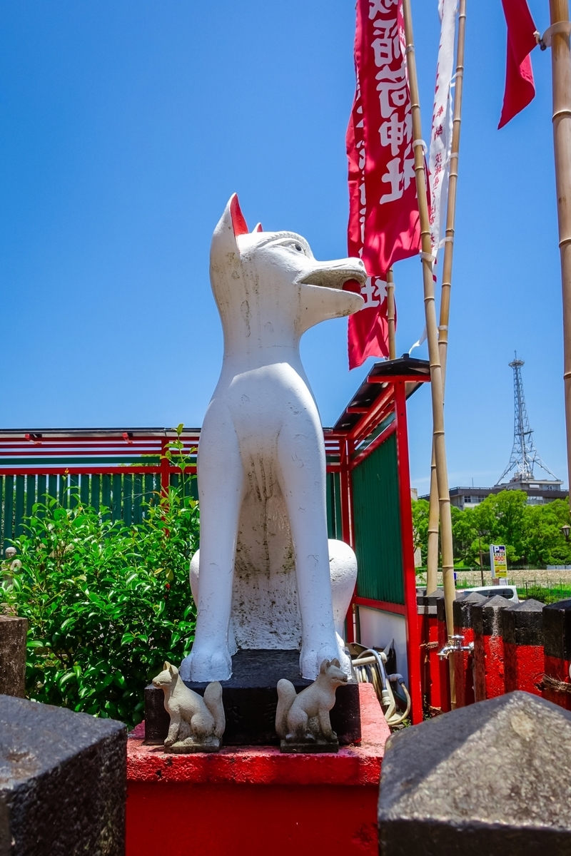 빨간 받침대 위에 앉은 흰 여우 신사상과 새끼 여우