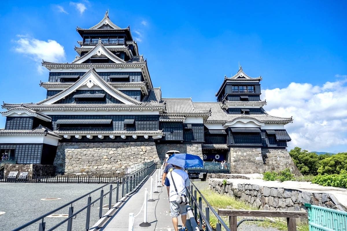 푸른 하늘 아래 구마모토성 대천수와 소천수로 향하는 견학 통로를 걷는 방문객들