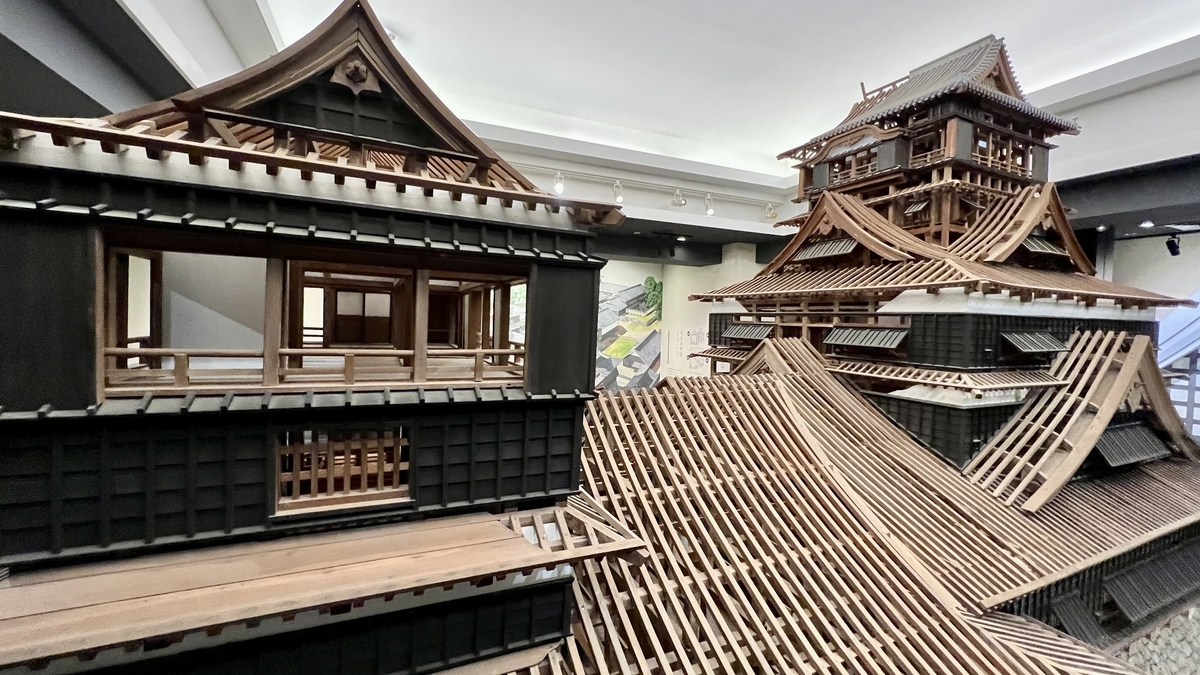 서까래가 노출된 지붕과 내부 방이 보이는 구마모토성 천수각 모형 측면