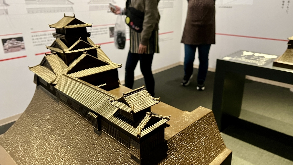 긴 연결 망루와 대천수가 이어진 구마모토성 미니어처를 석축 받침대째 전시한 모형