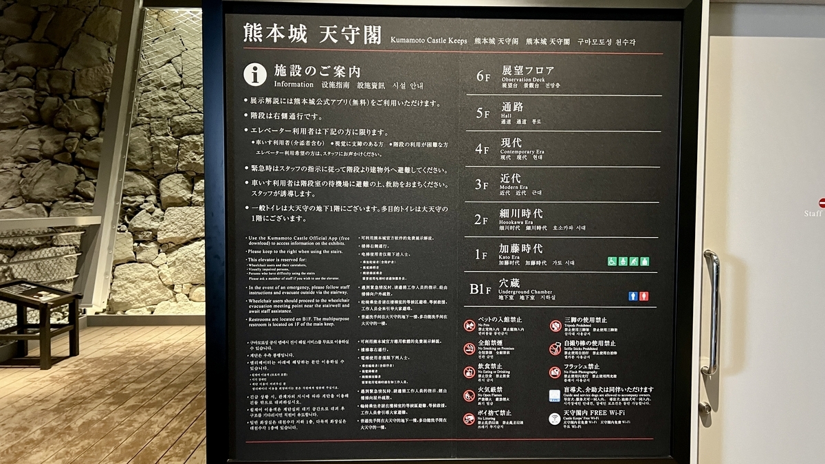 구마모토성 천수각의 층별 구성과 주의사항이 나열된 검은색 시설 안내판
