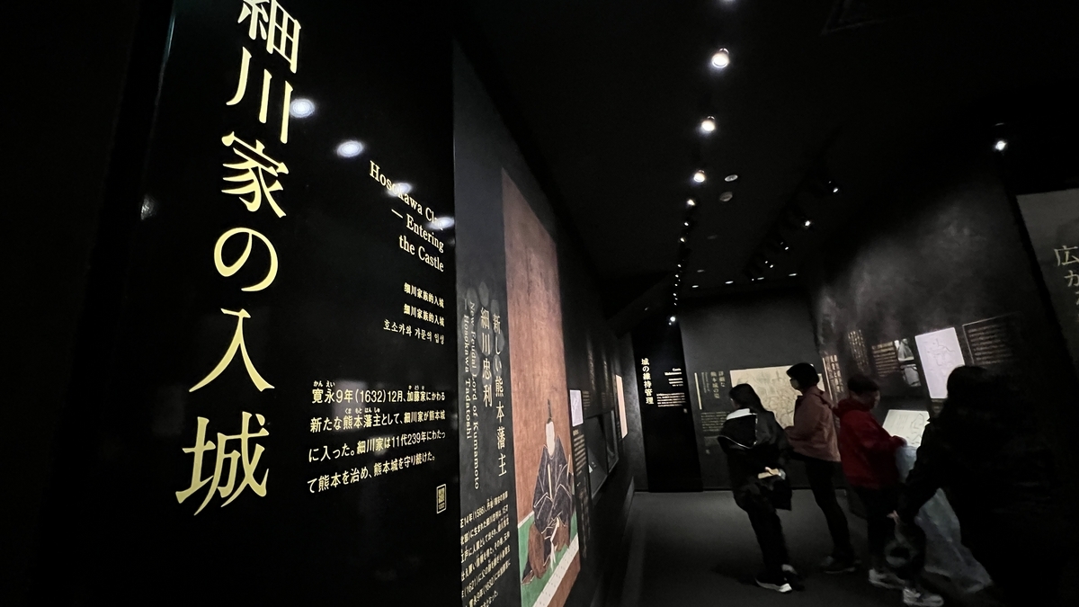 호소카와 가문의 입성을 설명하는 벽면 패널과 인물화 앞에서 전시를 읽는 방문객들