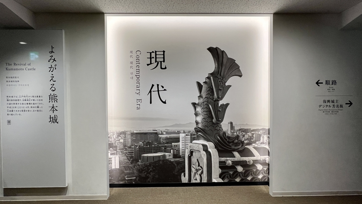 현대 전시 플로어 입구에 서 있는 샤치가와라 사진과 현대의 큰 문자 패널