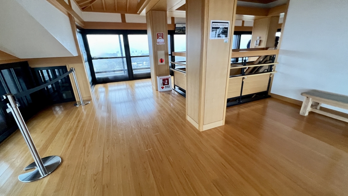 나무 바닥과 기둥으로 둘러싸인 6층 전망 플로어의 밝은 실내와 창가 공간