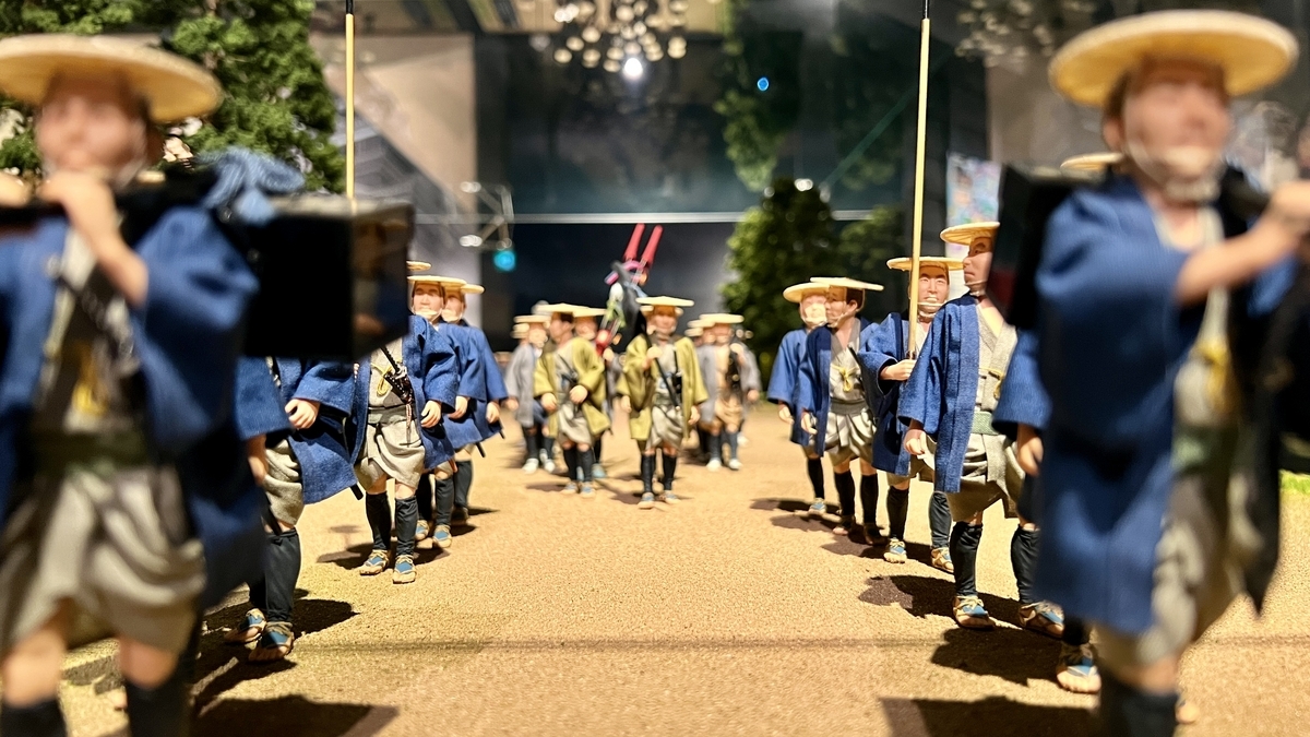 무사 복장의 인형들이 줄을 지어 있는 어입국어행렬 모형 근접 촬영