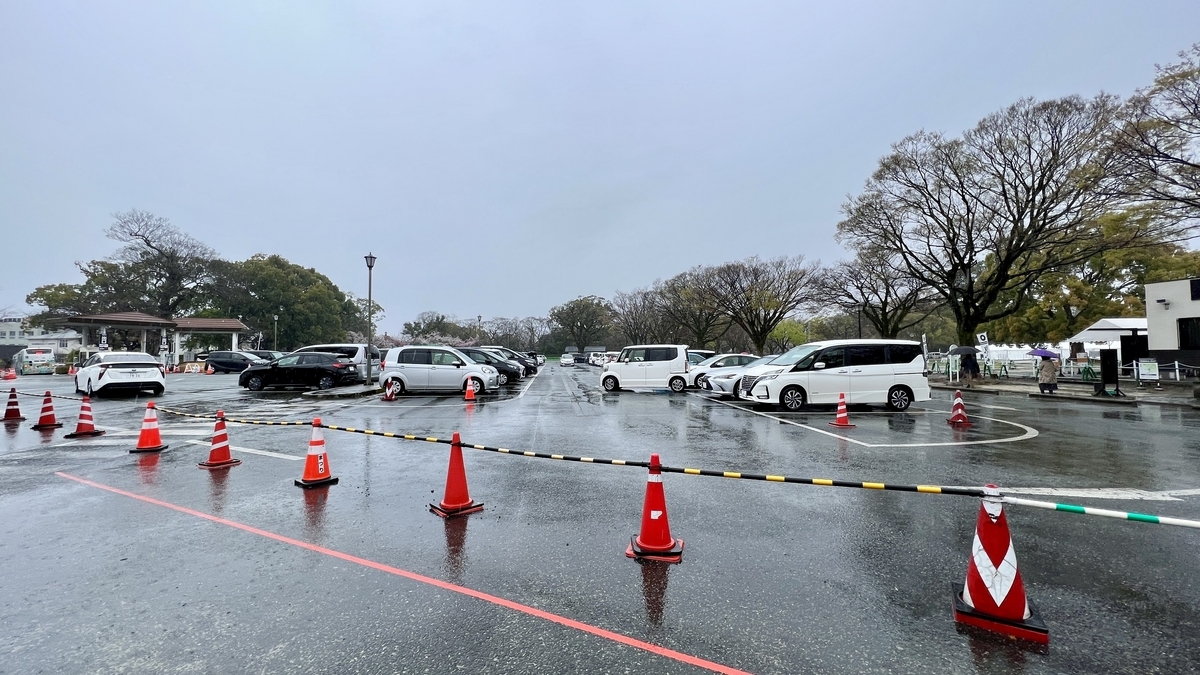 비 오는 날 니노마루 주차장에 주차된 차량들과 구역을 표시하는 콘