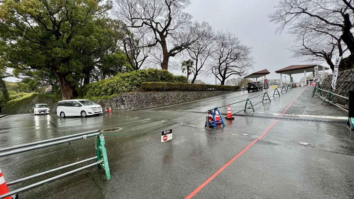 비 오는 도로에 있는 니노마루 주차장 입구 게이트와 안내판