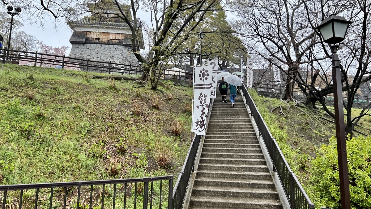 비 속에서 오르는 관광객과 구마모토성으로 이어지는 석계단