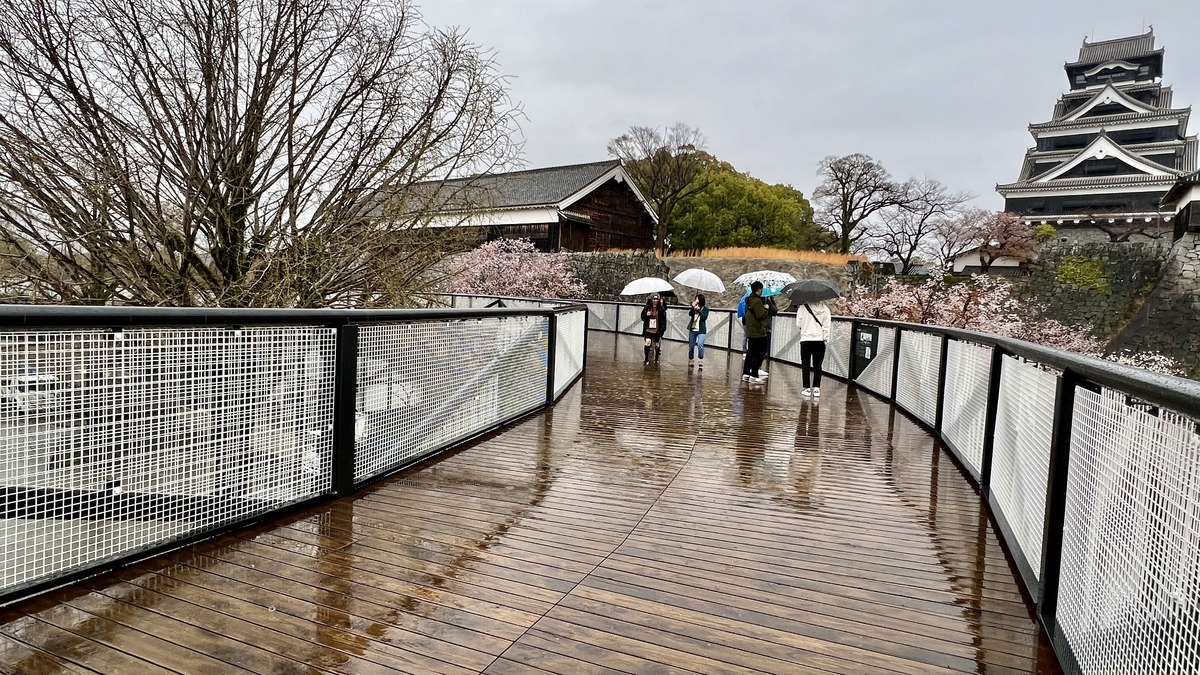 비에 젖은 남쪽 루트의 나무 데크와 구마모토성 천수각이 보이는 풍경