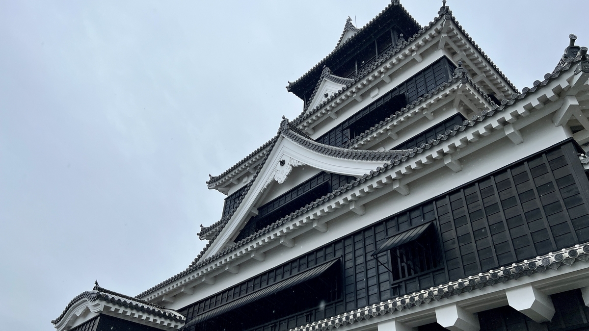 흰 파풍과 검은 벽이 돋보이는 구마모토성 대천수각을 올려다본 구도