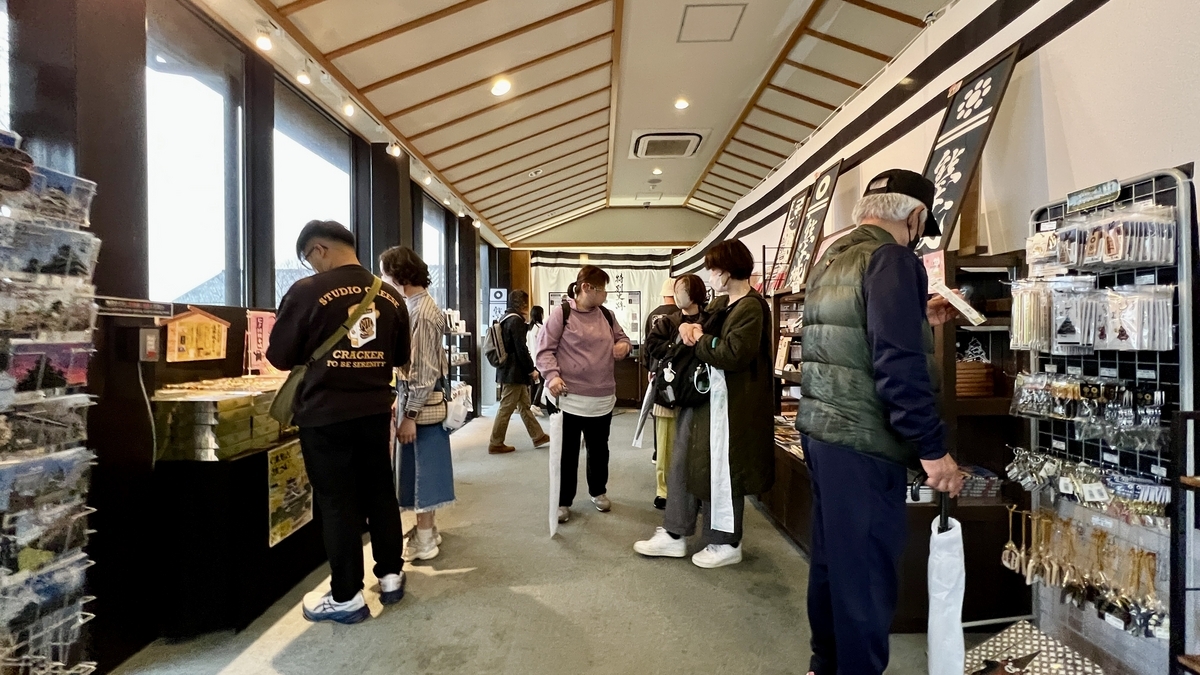 구마모토성 매점 통로에서 기념품을 고르는 관광객과 상품 진열대