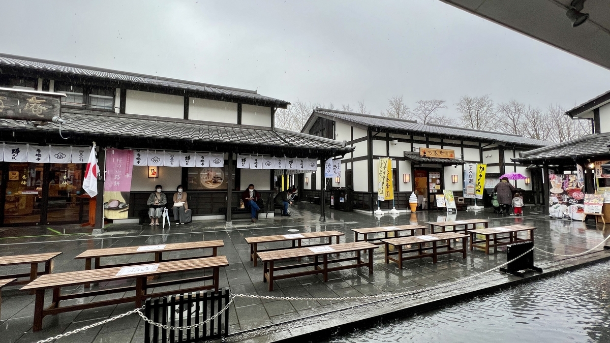 비 오는 성채원에 늘어선 음식점과 야외 벤치 좌석이 있는 중정