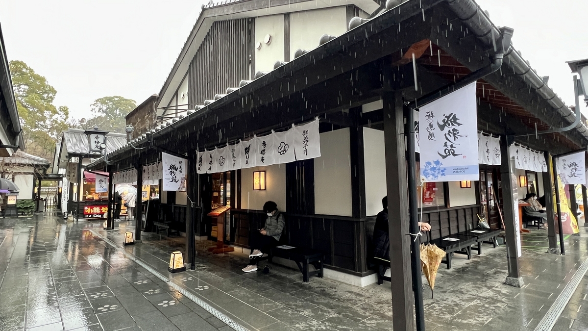 비 오는 돌길 통로에 늘어선 노렌과 성채원 음식점 외관
