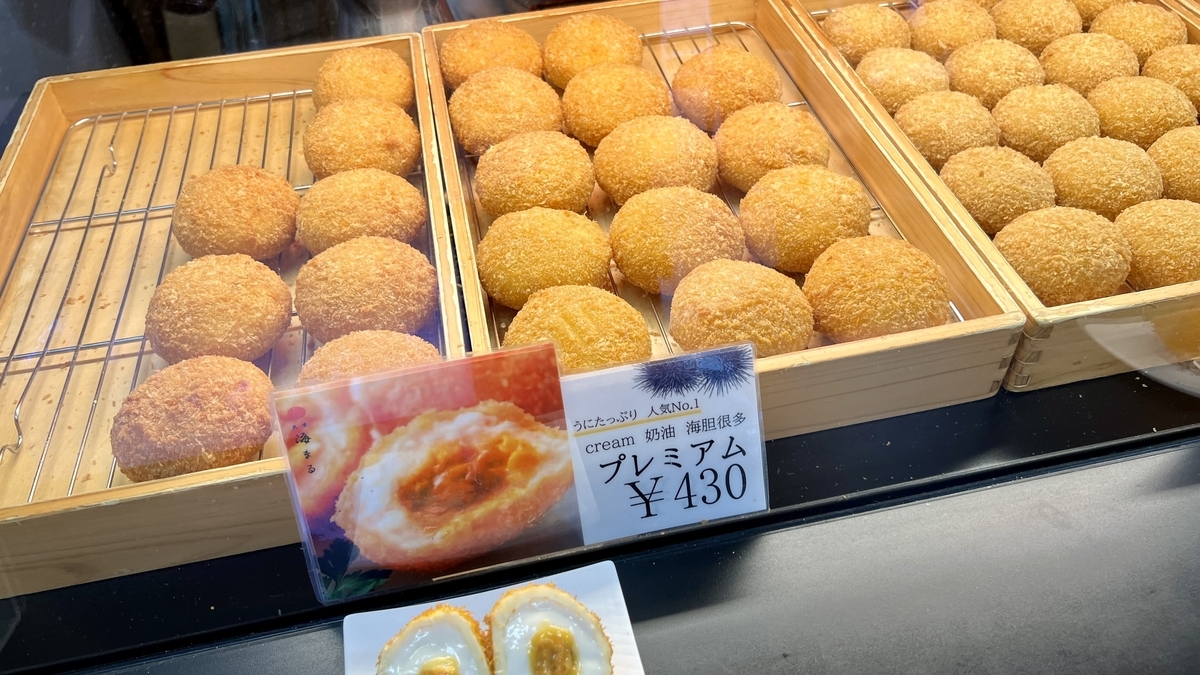 쇼케이스에 늘어선 갓 튀긴 우니 크로켓과 가격 표시