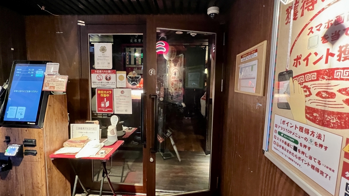 자동판매기 옆 접수 테이블과 안쪽으로 이어지는 입구 문의 매장 내 동선