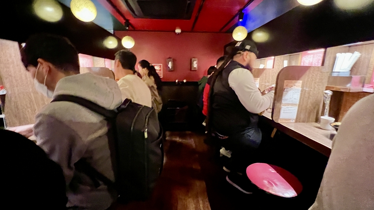 칸막이가 있는 맛 집중 카운터에서 주문 용지를 작성하는 손님석 모습