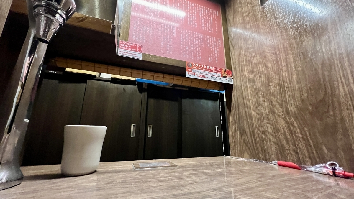 칸막이가 있는 맛 집중 카운터 좌석의 테이블과 주문 메뉴 게시