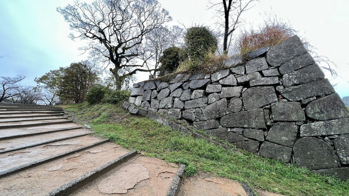 沿石階延續的東御門遺址石牆和枯樹斜坡