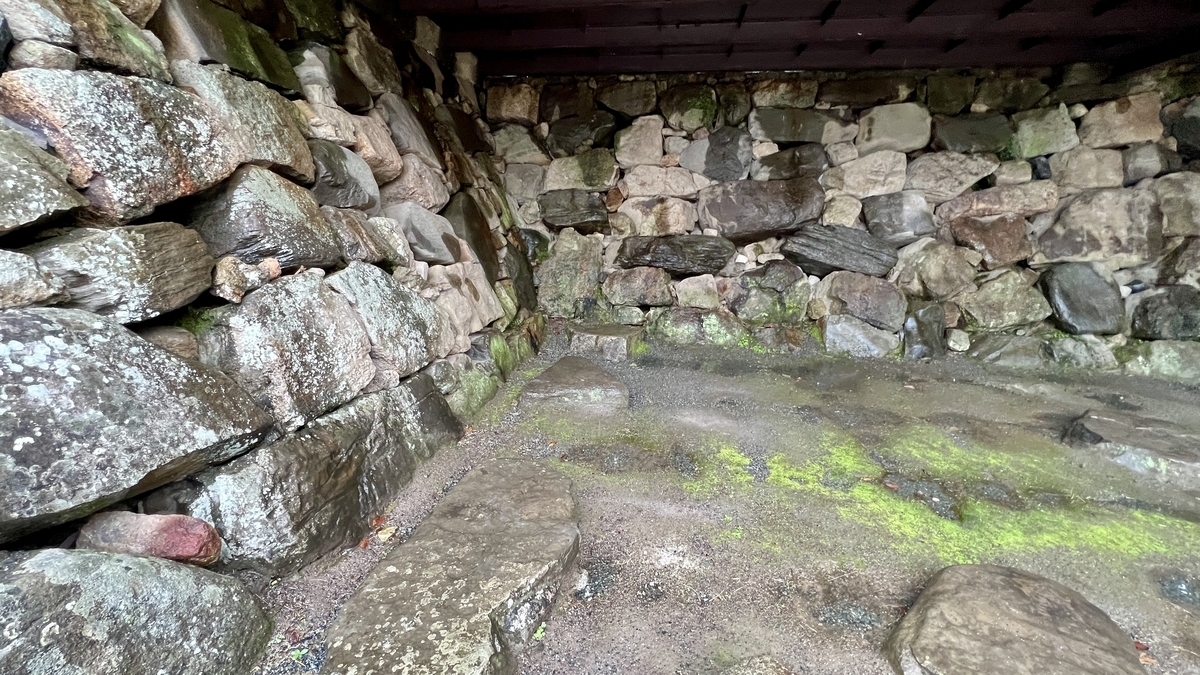大天守台遺址石牆背面殘留的礎石和苔蘚覆蓋的地面
