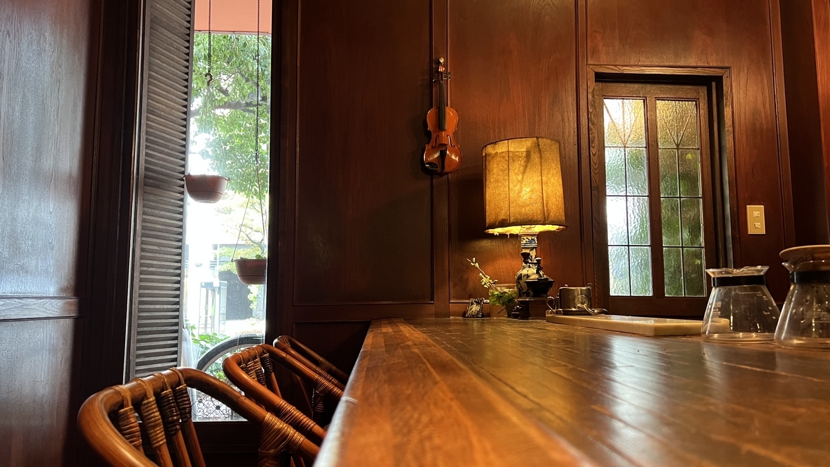 나무 벽과 라탄 의자가 늘어선 카운터석, 레트로한 랜턴이 켜진 내부