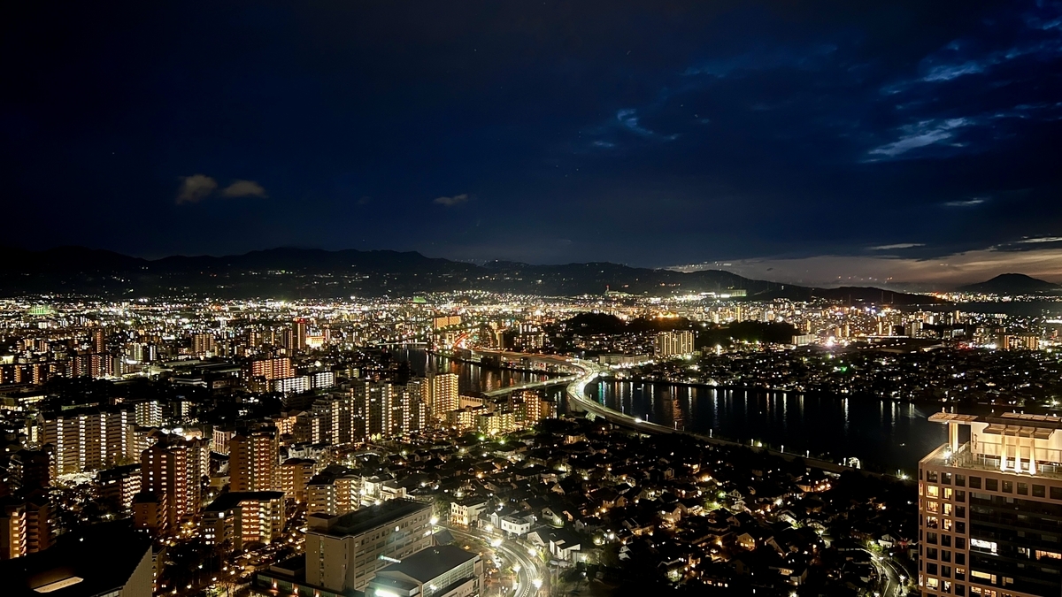Night view of Fukuoka with city lights stretching along the river and residential areas