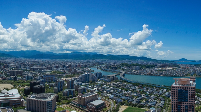 Daytime panoramic view of Fukuoka city and bay under blue sky with white clouds
