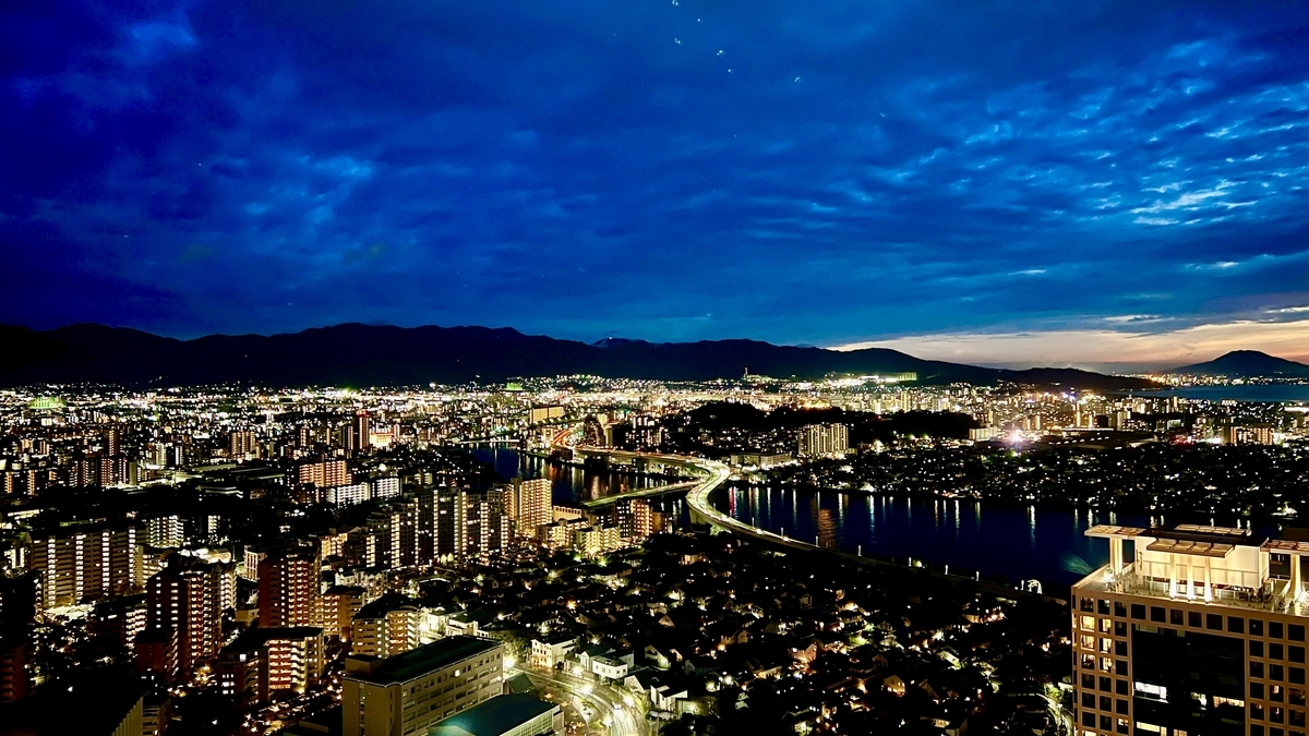 Night view of Fukuoka city lights with reflections streaming across the river surface