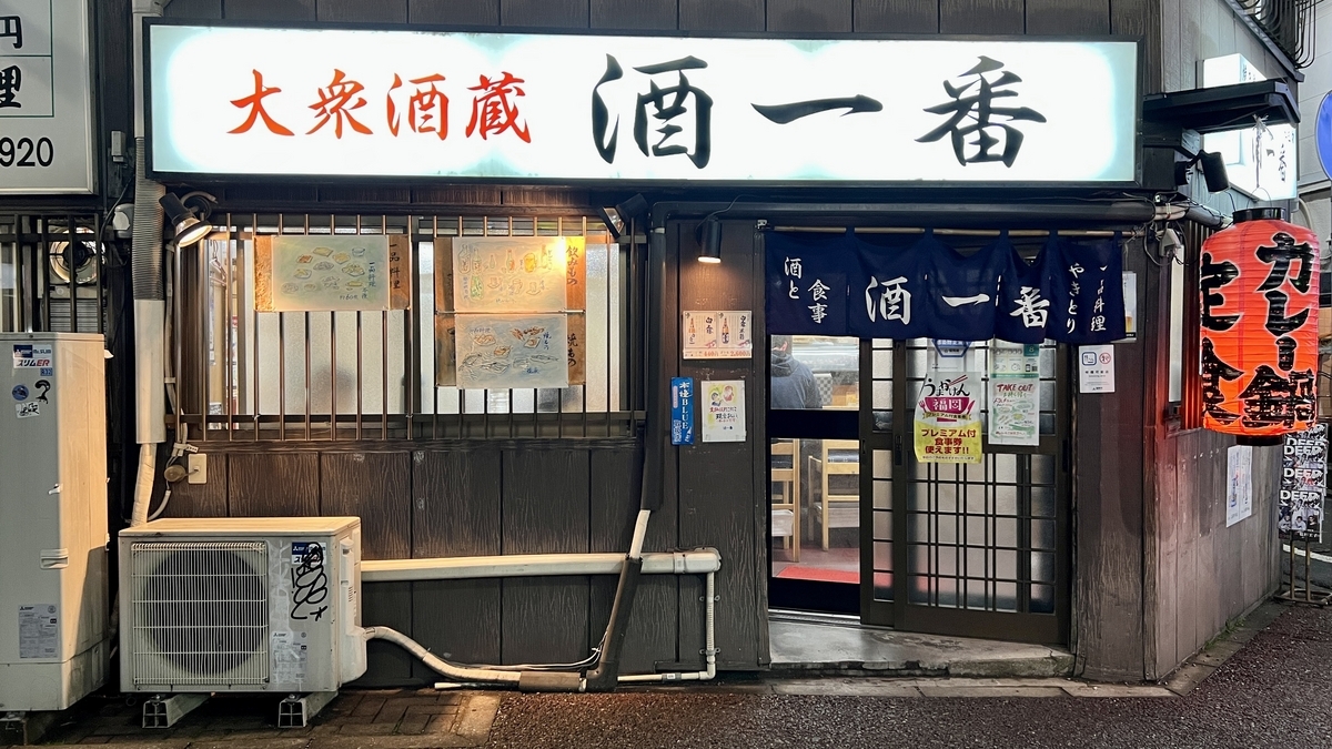 Entrada de Taishu Sakagura Sake Ichiban con letrero blanco y cortina noren tradicional