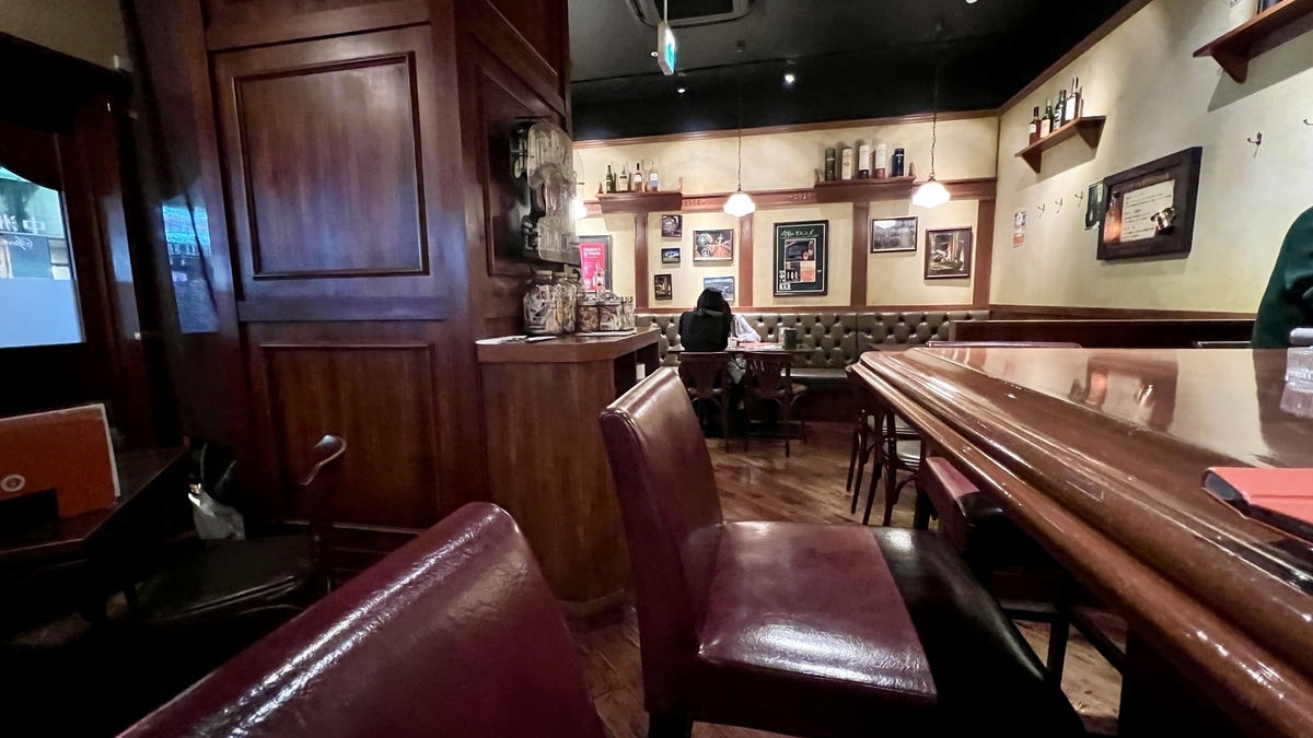 ダークブラウンの木目に包まれた店内のボックス席とカウンター席