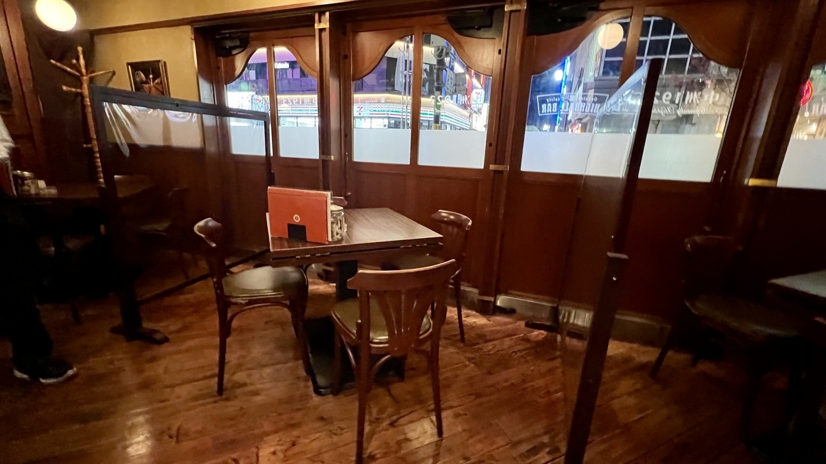 木の床とブラウンの壁に囲まれた窓際のテーブル席