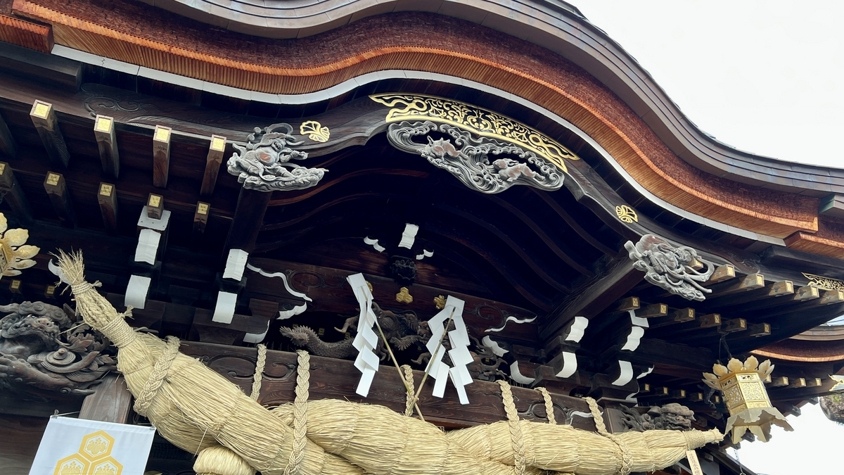 拝殿の軒下に並ぶ風神雷神の木彫りと太い注連縄