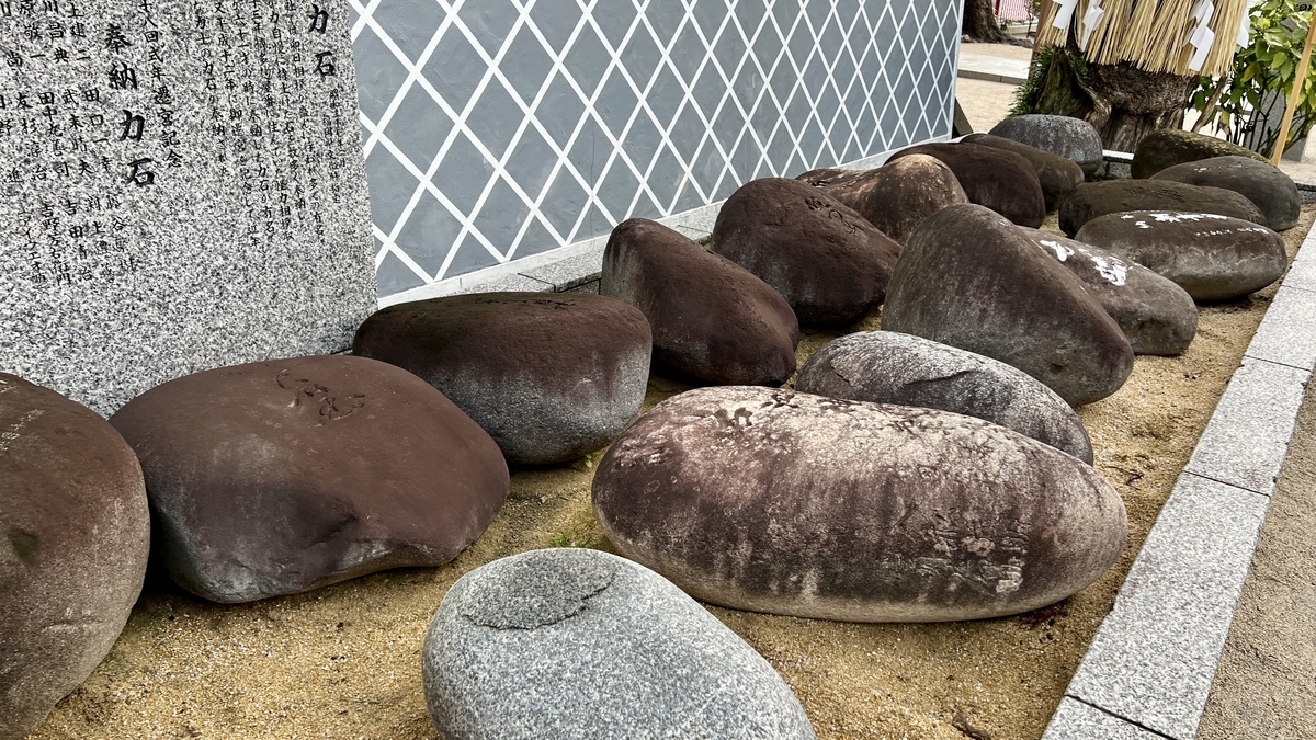 刻印のある力石が列をなす砂地の展示