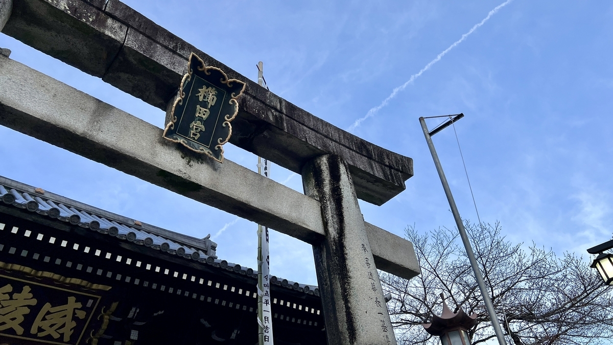 石鳥居の扁額と空を見上げた楼門前の景色