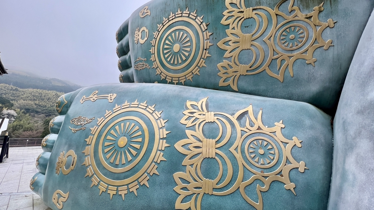 二つの仏足に描かれた金色の車輪文様と花文様