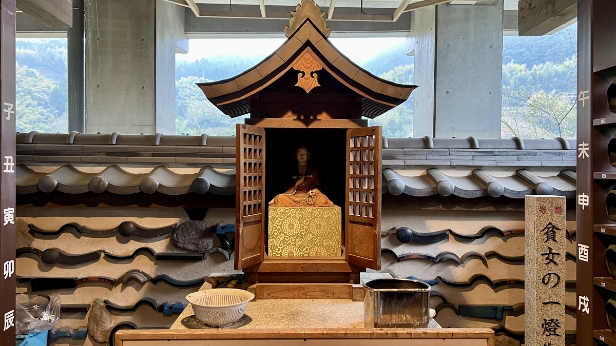 貧女の一燈の祠に安置された小さな仏像と供物台