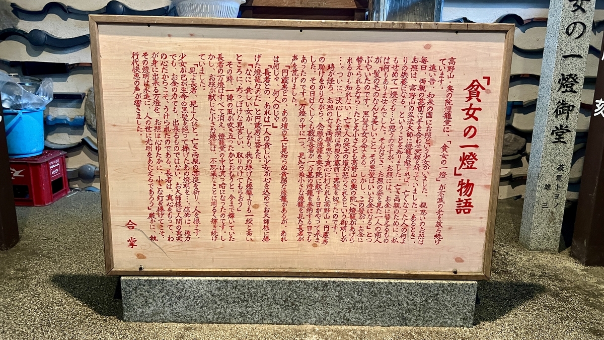 貧女の一燈物語の説明文が書かれた木製の案内板