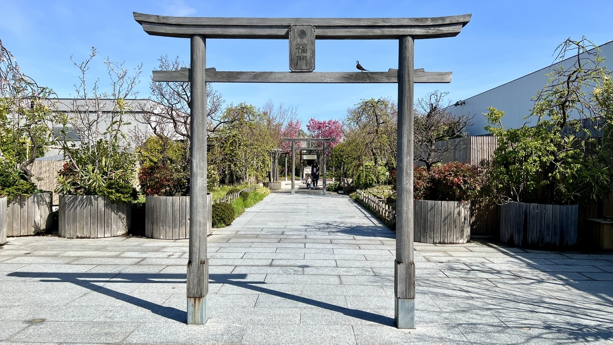 The second torii gate with Fukumon signboard surrounded by plants along the approach