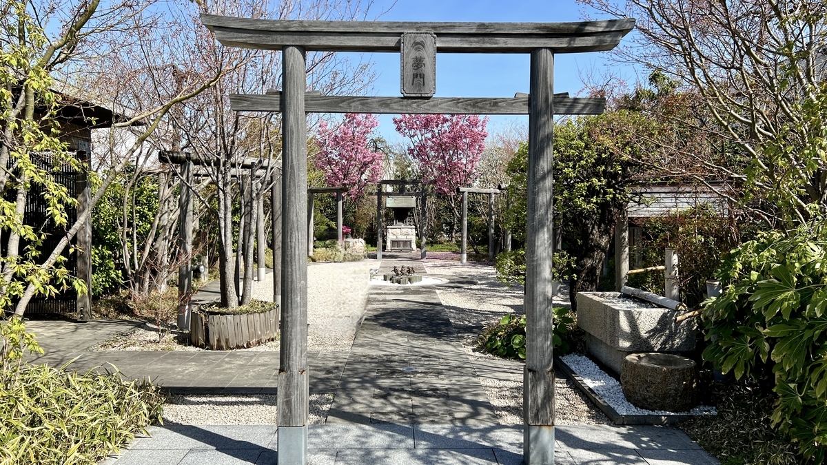 The third torii gate with Yumemon signboard and water basin in the background